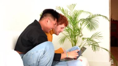 Güzel eşcinsel çift kanepede romantik oluyor kucaklaşıyorlar, Igbt konsepti, online alışveriş yapıyorlar.