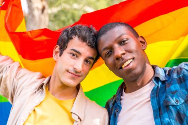 Gökkuşağı lgbt sembolü taşıyan eşcinsel bir çiftin portresi. Romantik poz.