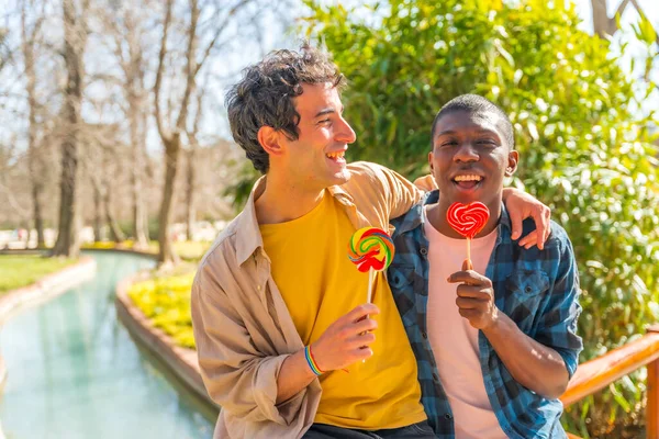 多种族男同性恋夫妇吃棒棒糖 棒棒糖的概念 浪漫的乐趣 — 图库照片