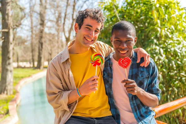 多种族男同性恋夫妇吃棒棒糖 棒棒糖的概念 浪漫的自然乐趣 — 图库照片