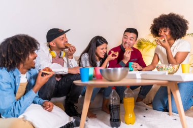 Bir grup çok ırklı arkadaş bir kanepede pizza yiyip gazoz içiyorlar, pizza yiyorlar ve komik hikayeler anlatıyorlar.