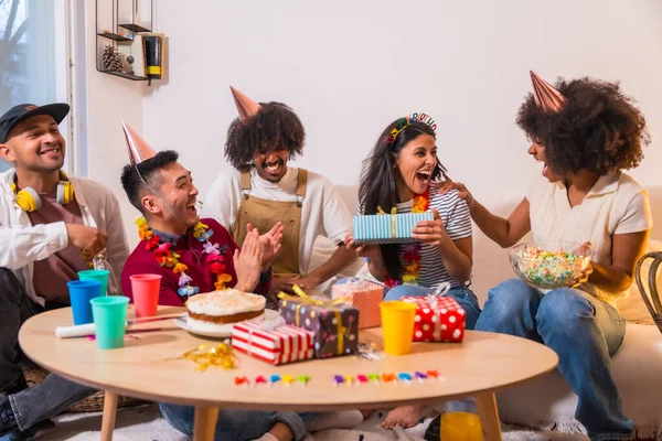 自宅でのソファの上の誕生日パーティーでの友人のグループは 贈り物を提供し 驚くべきことに誕生日の女の子 — ストック写真