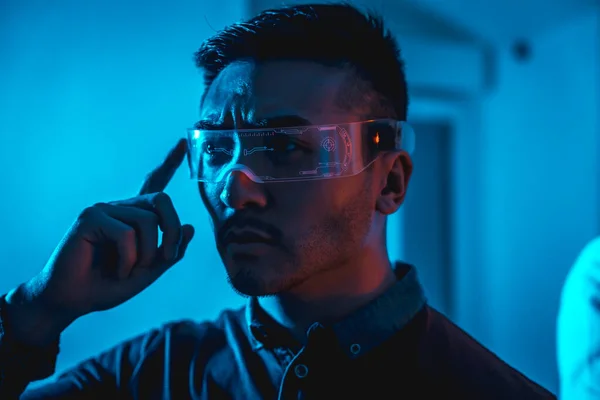 stock image Young chinese man with neon glasses with a blue light, futuristic concept, cyber human technology