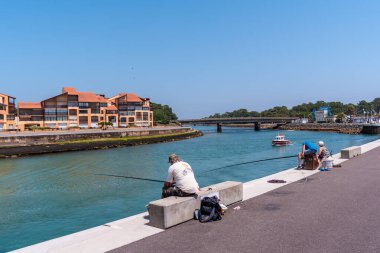 Fransız Bask Bölgesi kıyısındaki Capbreton köyü, Fransa 'da, nehirde balık tutan yaşlılar.