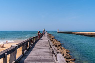 Fransız Bask Bölgesi kıyısındaki Capbreton köyü, Fransa 'da turistlerle ahşap geçit.