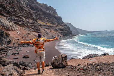 El Hierro Adası 'ndaki Verodal plajında oturan bir turist. Kanarya Adaları, sevincin tadını çıkarıyor