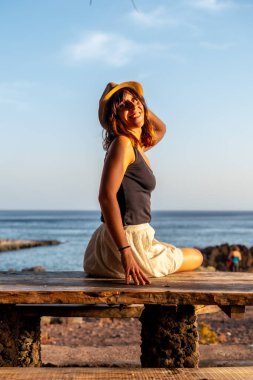 El Hierro, Kanarya Adaları 'ndaki Tacoron sahilinde gün batımında bir kadın turistin portresi.