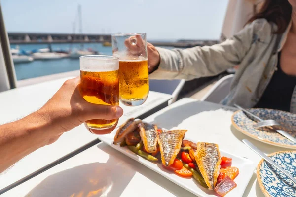 Ein Paar Prostet Mit Bier Meer Und Isst Gebratenen Fisch — Stockfoto