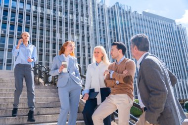 İşe gitmeden önce konuşmak. Bir grup iş arkadaşı dışarıda, bir şirket ofisinde.