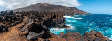 İspanya 'nın Kanarya Adaları' ndaki El Hierro adasındaki Tamaduste kasabasında volkanik taşlı kayalıkların panoramik görüntüsü.