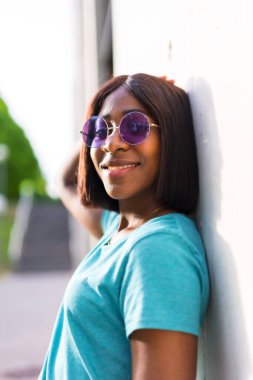 Yeni Ufuklar Keşfeden: Yeşil tişörtlü ve güneş gözlüklü Güzel Siyah Bir Turist Kadının Portresi