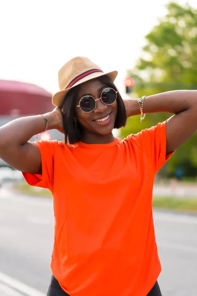 Νεαρή Μαύρη Γυναίκα Πορτοκαλί Shirt Γυαλιά Ηλίου Και Καπέλο Απολαμβάνοντας — Φωτογραφία Αρχείου