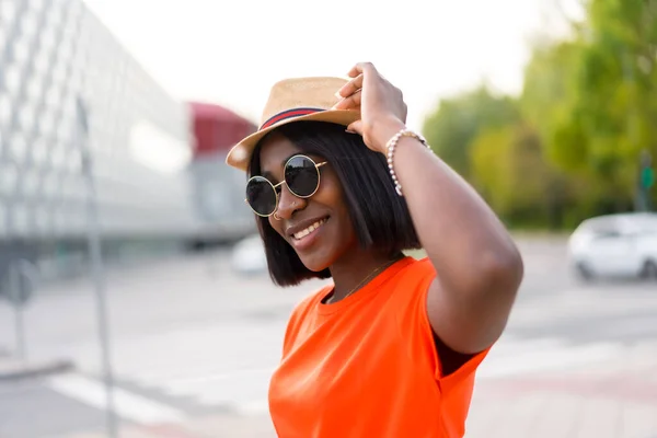 Νεαρή Μαύρη Γυναίκα Γυαλιά Ηλίου Και Καπέλο Πορτοκαλί Shirt Χαμογελαστή — Φωτογραφία Αρχείου