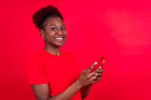 Νεαρή Αφροαμερικανή Γυναίκα Απομονωμένη Κόκκινο Φόντο Χαμογελώντας Κινητό Τηλέφωνο Συνεδρία — Φωτογραφία Αρχείου