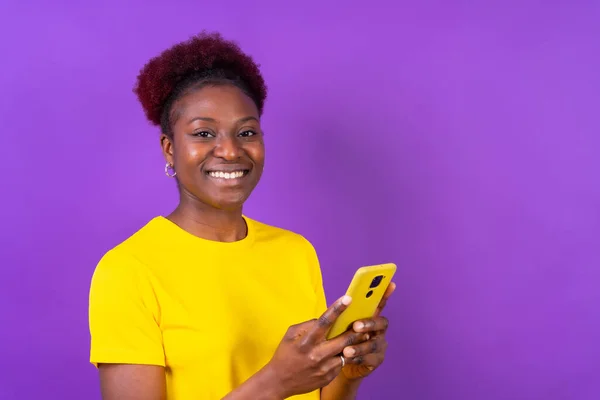 Młoda Afroamerykanka Odizolowana Fioletowym Tle Uśmiechnięta Telefonem Komórkowym Sesja Naukowa — Zdjęcie stockowe