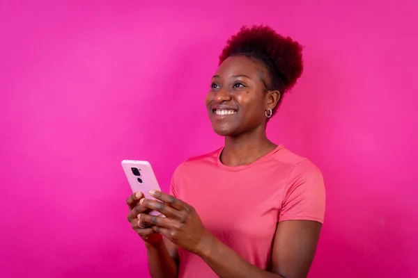 Młoda Afroamerykanka Odizolowana Różowym Tle Uśmiechnięta Telefonem Komórkowym Sesja Naukowa — Zdjęcie stockowe