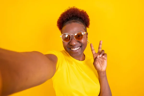 Νεαρή Αφροαμερικανή Γυναίκα Απομονωμένη Κίτρινο Φόντο Χαμογελώντας Και Βγάζοντας Μια — Φωτογραφία Αρχείου