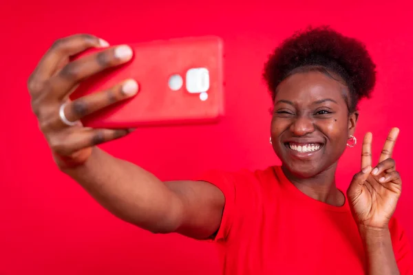 Νεαρή Αφροαμερικανή Γυναίκα Απομονωμένη Κόκκινο Φόντο Χαμογελώντας Και Βγάζοντας Μια — Φωτογραφία Αρχείου