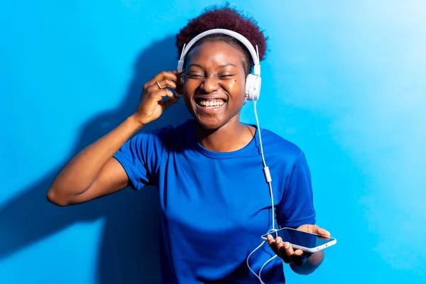 Νεαρή Αφροαμερικανή Γυναίκα Απομονωμένη Μπλε Φόντο Ακουστικά Χορεύουν Φωτογράφιση Στούντιο — Φωτογραφία Αρχείου