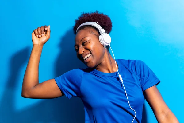 Νεαρή Αφροαμερικανή Γυναίκα Απομονωμένη Μπλε Φόντο Ακουστικά Χορεύουν Φωτογράφιση Στούντιο — Φωτογραφία Αρχείου