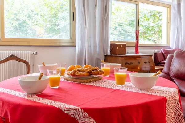 Breakfast on the table with a tablecloth in the living room at home, healthy breakfast with juices and fruits and curasans