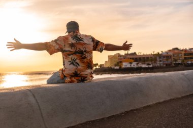Gün batımında turist, Kanarya Adaları, La Gomera 'daki Valle Gran Rey köyünde tatilin tadını çıkarıyor.