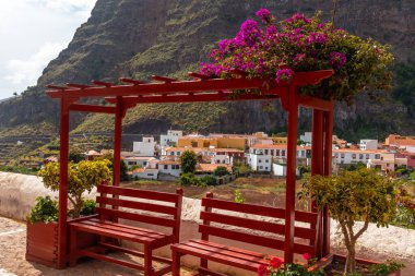 Yazın La Gomera 'nın kuzeyindeki Agulo köyünün sokaklarında kırmızı banklar, Kanarya Adaları