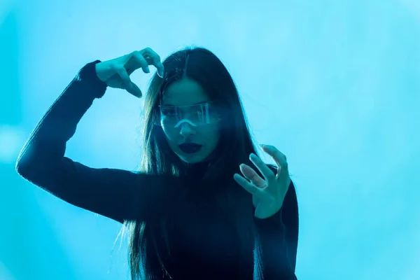 メタバース技術の概念 女性で未来的な眼鏡でLedライト上の青の背景 — ストック写真