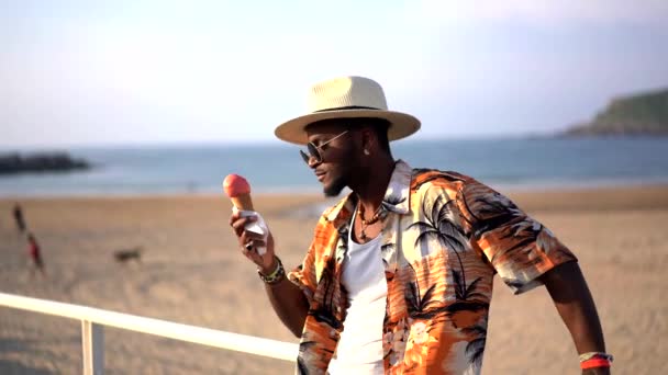 Чорний Етнічний Чоловік Насолоджується Літнім Відпочинком Пляжі Їдять Морозиво Насолоджуючись — стокове відео