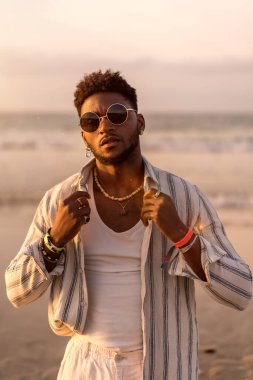 Siyah etnik modelin portresi deniz kenarında yaz tatilinin keyfini çıkarıyor