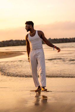 Siyah etnik modelin portresi deniz kenarında geçirdiği yaz tatilinin keyfini çıkarıyor.