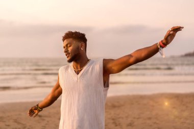 Siyah etnik modelin portresi deniz kenarında tatilin tadını çıkarıyor.