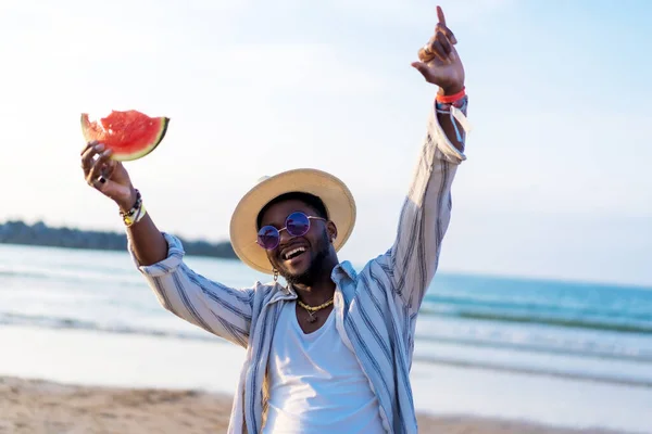 남자는 해변에서 휴가를 즐기면서 수박을 먹는다 — 스톡 사진