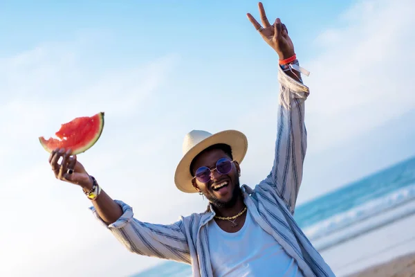 남자는 해변에서 휴가를 즐기면서 수박을 먹는다 — 스톡 사진
