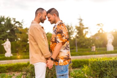 Şehirdeki bir parkta gün batımında birbirlerine bakan eşcinsel bir çiftin romantik portresi. Çeşitlilik ve lgbt kavramı