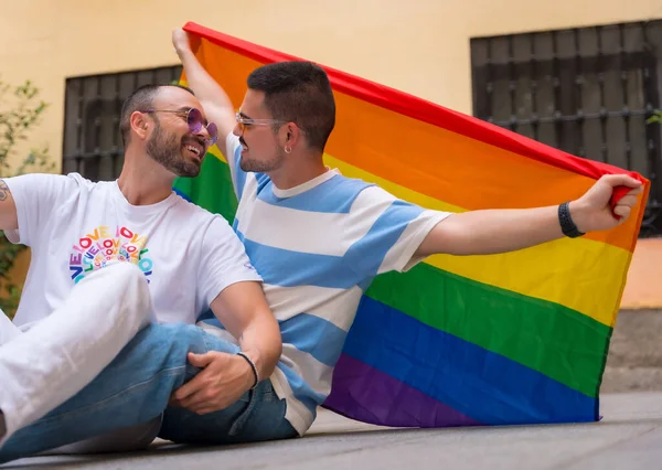 骄傲派对上 一对同性恋男伴坐在地板上 带着彩虹旗的肖像 Lgbt概念 — 图库照片