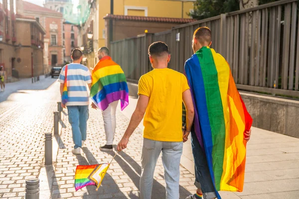 同志骄傲派对在城市里 男人们背着彩虹旗 昂首阔步走向游行 — 图库照片