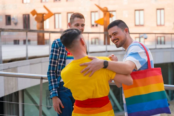 朋友们挥舞着彩虹的旗帜拥抱在示威现场 城市里的同志骄傲派对 这只是个概念 — 图库照片