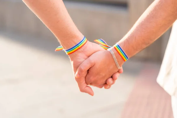 在这个城市的骄傲派对上 两个拿着彩虹旗的同性恋男人手牵手的细节 Lgbt概念 — 图库照片