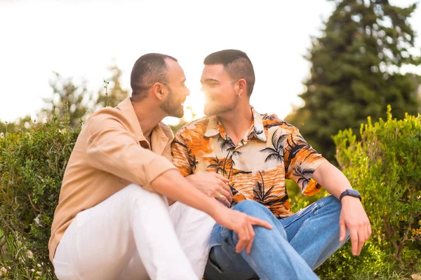 在城市的一个公园里 一对同性恋新婚夫妇坐在夕阳西下亲吻的浪漫画像 多样性和Lgbt概念 — 图库照片