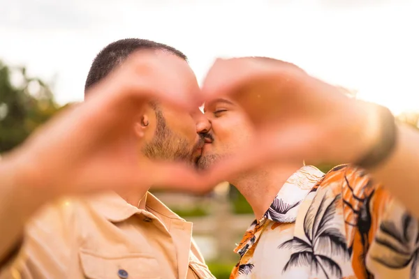 在城市的一个公园里 一个同性恋男友和女友在日落时亲吻自己的心或爱的姿势的画像 多样性和Lgbt概念 — 图库照片