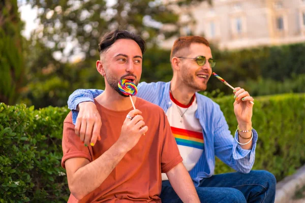 城市日落时分 一对笑容满面的新婚夫妇在公园里吃棒棒糖的画像 多样性和Lgbt生活方式概念 — 图库照片
