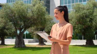 Ofisin dışında tapuları imzaladıktan sonra gülümseyen bir emlakçının anahtarlarını vermek.