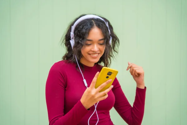 헤드폰을 여성의 배경에 기술적 음악듣기 — 스톡 사진