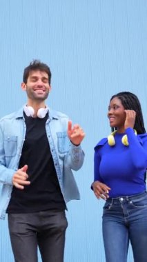 Mavi arka planda siyah ırktan iki beyaz erkek ve kadın dans eden salsa ve latin müzik yapıyorlar.