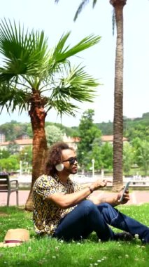 Yaz tatilindeki afro saçlı adam sahildeki palmiye ağaçlarının yanında. Seyahat ve turizm kavramı