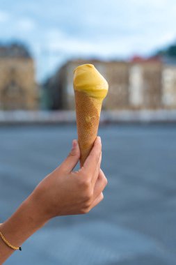 Yaz tatilinde sahilde mangolu dondurma yiyen genç bir arkadaşın eli.