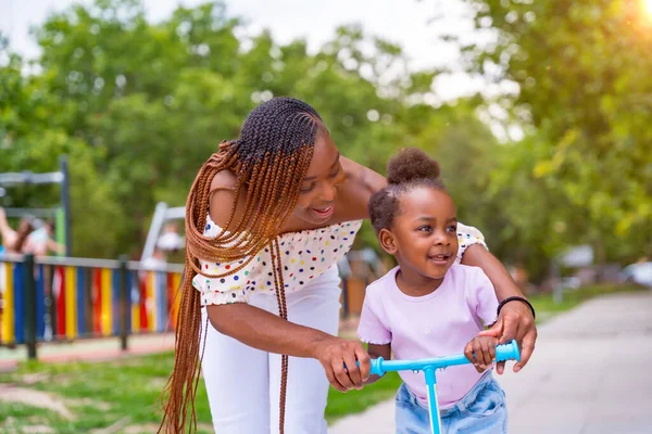 Musta Afrikkalainen Etnisyys Äiti Hauskaa Tyttärensä Kanssa Leikkikentällä Oppiminen Ratsastaa — kuvapankkivalokuva