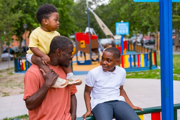Afrikkalainen Musta Etnisyys Isä Puhuu Lastensa Kanssa Kaupungin Puiston Leikkikentällä — kuvapankkivalokuva