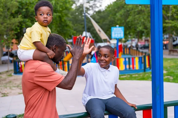 아프리카 아버지 놀이터에서 자녀들 흔들고 — 스톡 사진